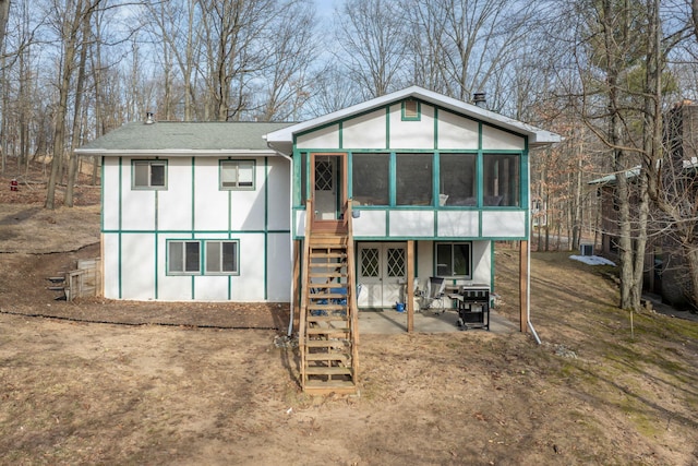 rear view of property featuring stairway and a sunroom