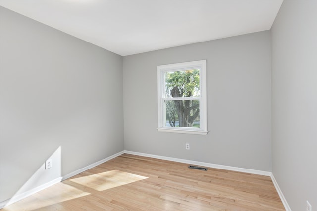 spare room with visible vents, baseboards, and light wood-style floors