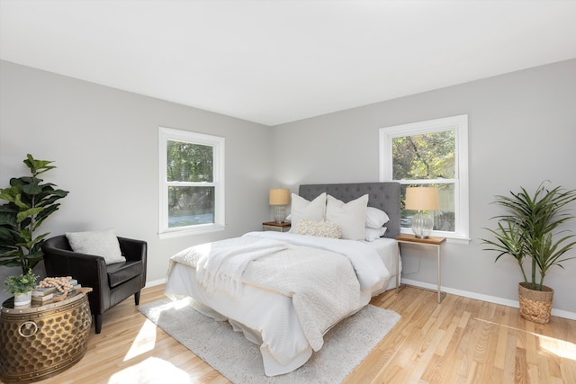 bedroom featuring baseboards and light wood finished floors