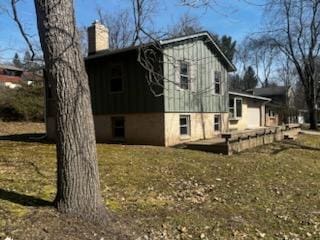 view of home's exterior featuring a chimney and a yard