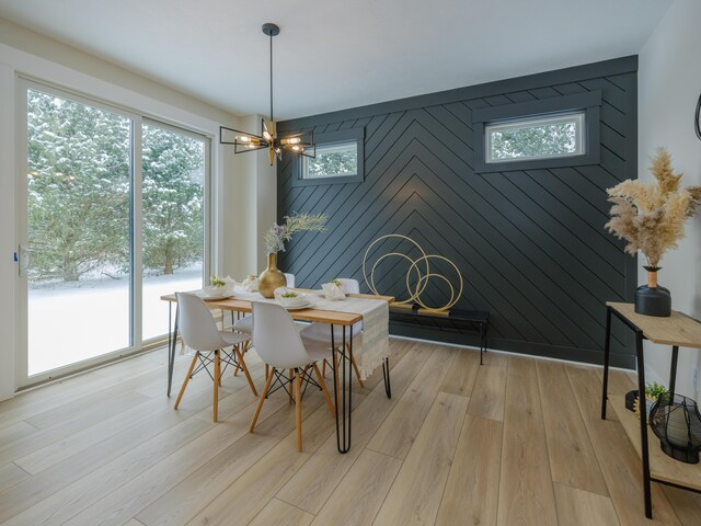 dining room featuring a notable chandelier, baseboards, and light wood-type flooring