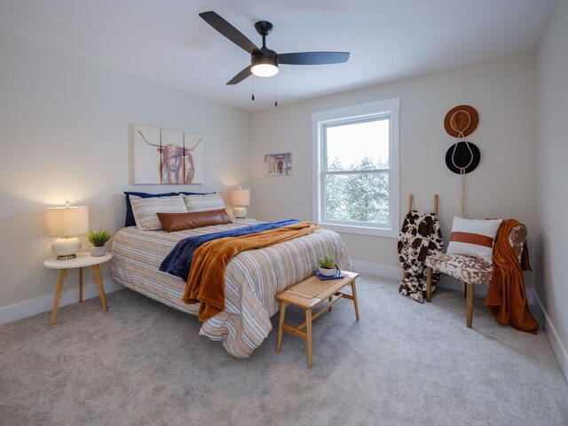 carpeted bedroom featuring baseboards and a ceiling fan