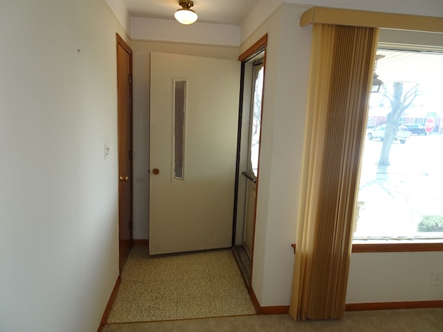 hallway with light floors and baseboards