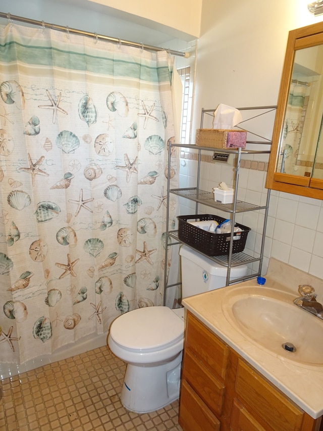 full bath featuring a shower with shower curtain, tile walls, toilet, and vanity