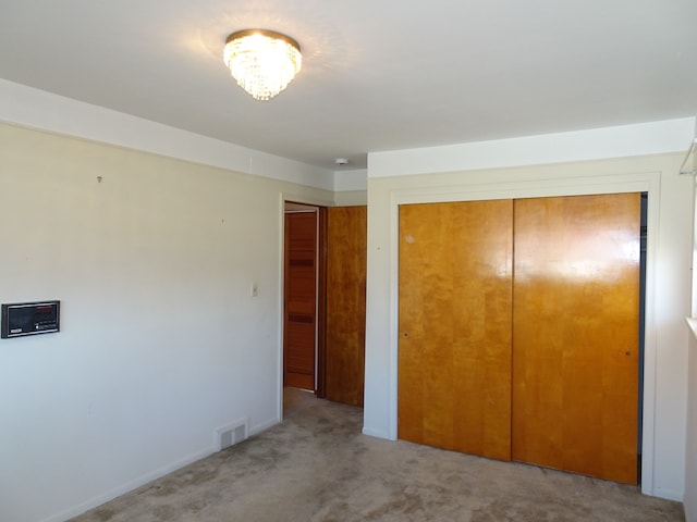 unfurnished bedroom with a closet, visible vents, and carpet floors