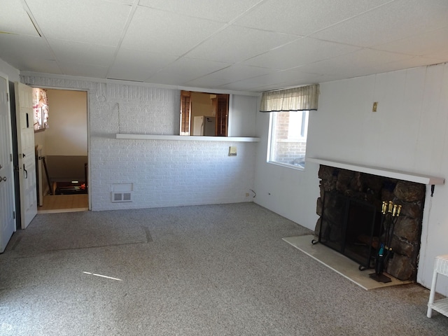 unfurnished living room featuring carpet flooring, a fireplace, and visible vents