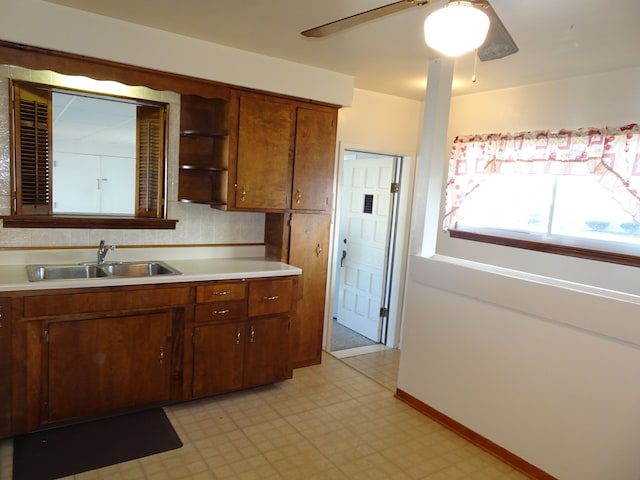 kitchen featuring light countertops, light floors, open shelves, and a sink