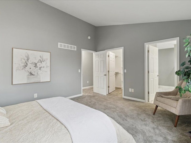 bedroom with baseboards, visible vents, carpet floors, vaulted ceiling, and a spacious closet