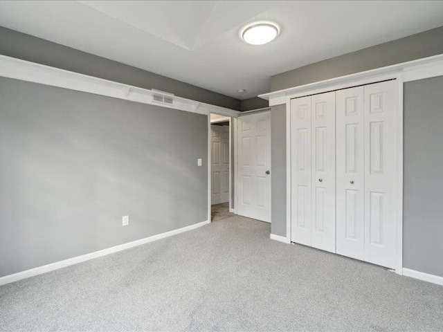 unfurnished bedroom featuring a closet, carpet flooring, visible vents, and baseboards