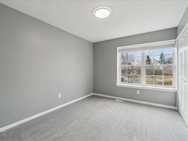 empty room with baseboards and carpet