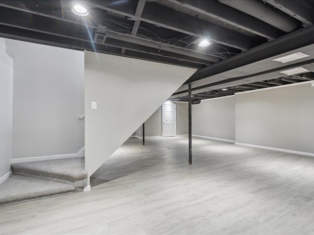 finished basement featuring wood finished floors and baseboards