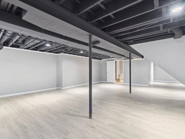 finished basement with baseboards and wood finished floors