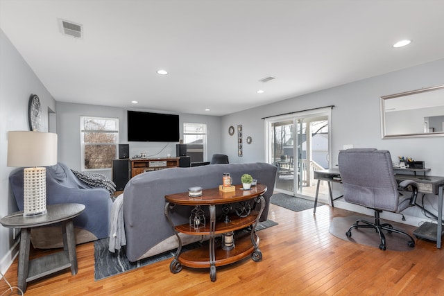 living room with light wood-style flooring, recessed lighting, and visible vents