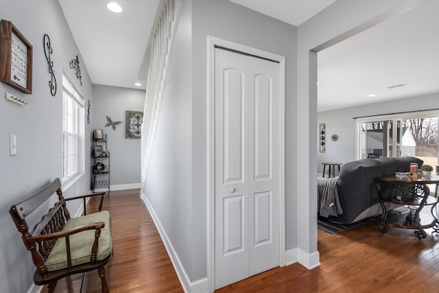 hallway featuring recessed lighting, baseboards, a healthy amount of sunlight, and hardwood / wood-style floors