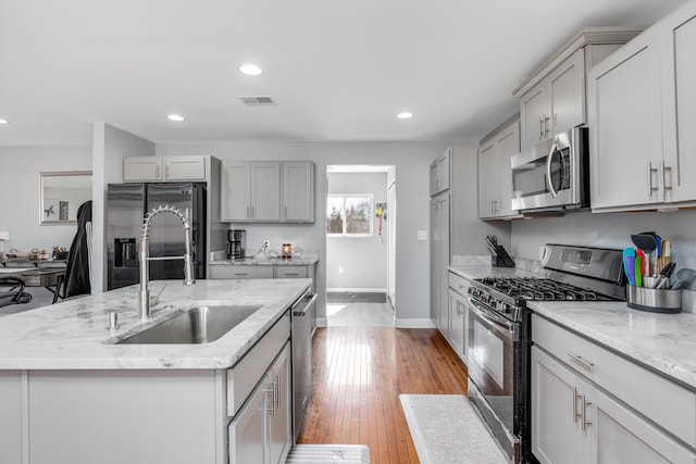 kitchen featuring a sink, gray cabinetry, light wood-style floors, and stainless steel appliances