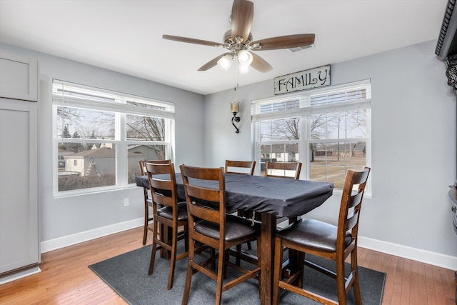 dining space with plenty of natural light, light wood-style flooring, and baseboards