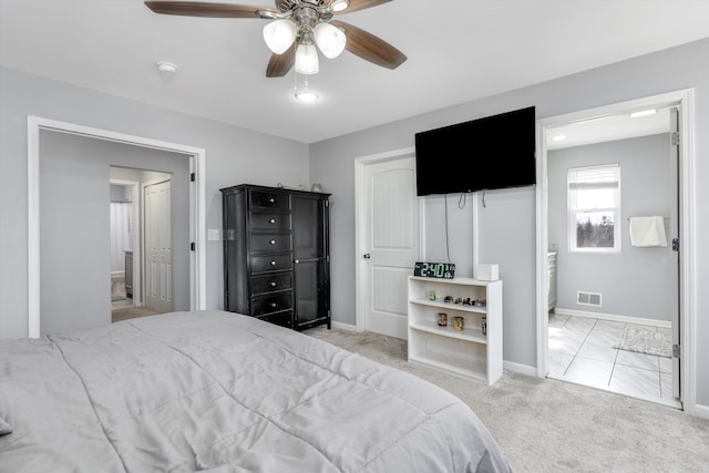 carpeted bedroom with a ceiling fan, ensuite bath, baseboards, and visible vents