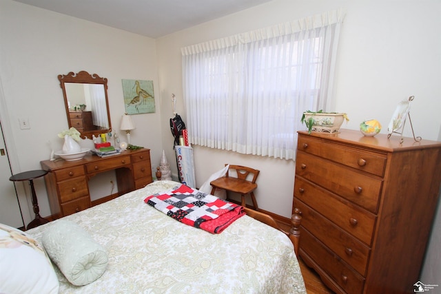 bedroom with baseboards and wood finished floors