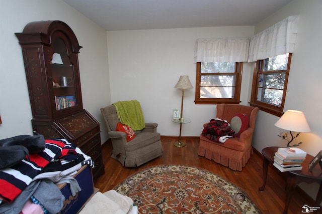 living area with baseboards and wood finished floors