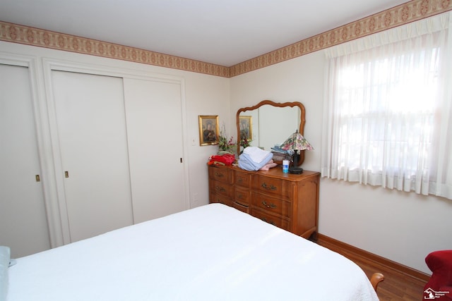 bedroom featuring baseboards and wood finished floors