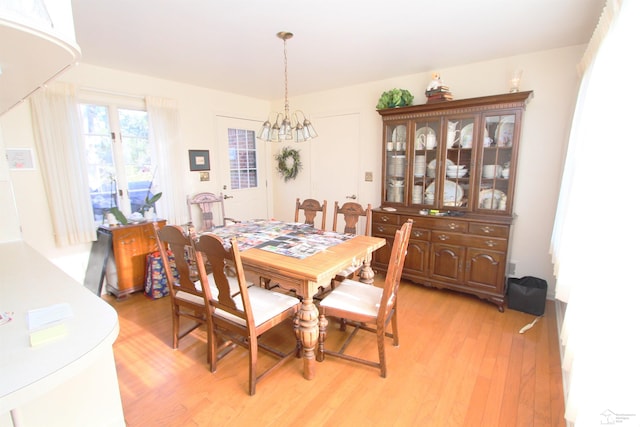 dining space with a notable chandelier and light wood-style floors