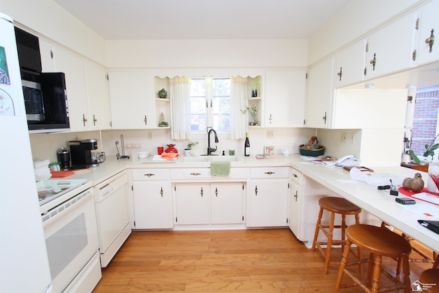 kitchen featuring open shelves, a sink, white appliances, light wood-style floors, and light countertops