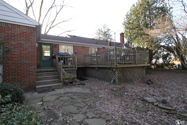 back of house featuring a deck, brick siding, and entry steps