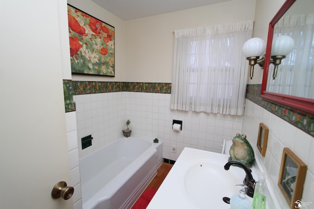 bathroom with a bath, a wainscoted wall, tile walls, and a sink