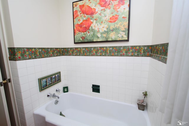 bathroom featuring a bathtub, a wainscoted wall, and wallpapered walls