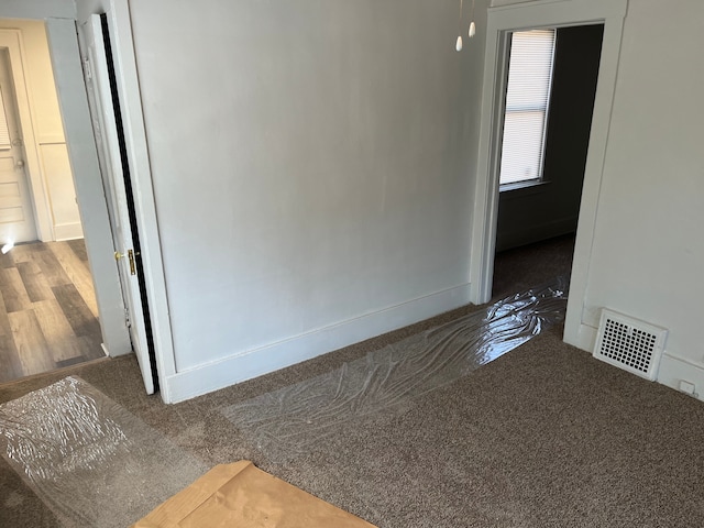 unfurnished room with visible vents and baseboards