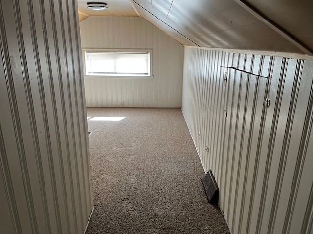 additional living space featuring lofted ceiling, wooden walls, and carpet