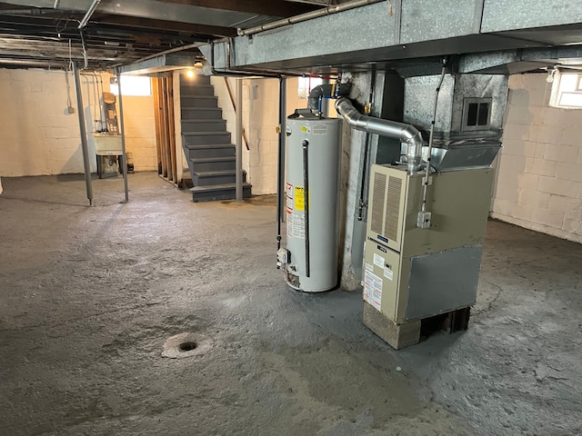 basement featuring heating unit, stairway, and gas water heater