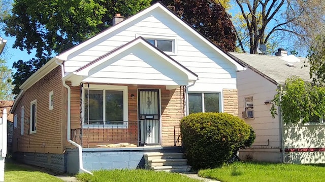 bungalow with covered porch and a chimney