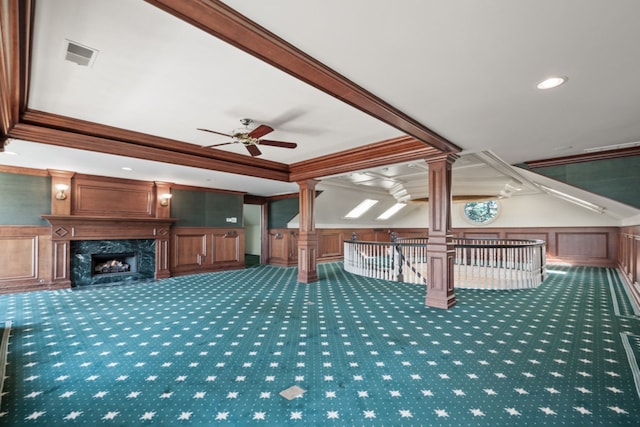 interior space featuring visible vents, carpet, ceiling fan, wainscoting, and a fireplace