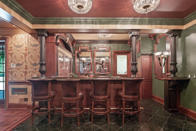 bar featuring ornamental molding, granite finish floor, wallpapered walls, baseboards, and ornate columns