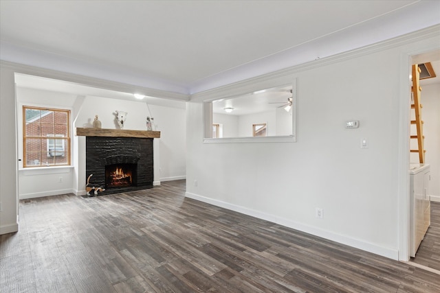 unfurnished living room with baseboards, dark wood-type flooring, and a fireplace