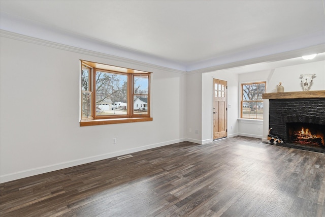 unfurnished living room featuring a stone fireplace, dark wood-style floors, visible vents, and baseboards