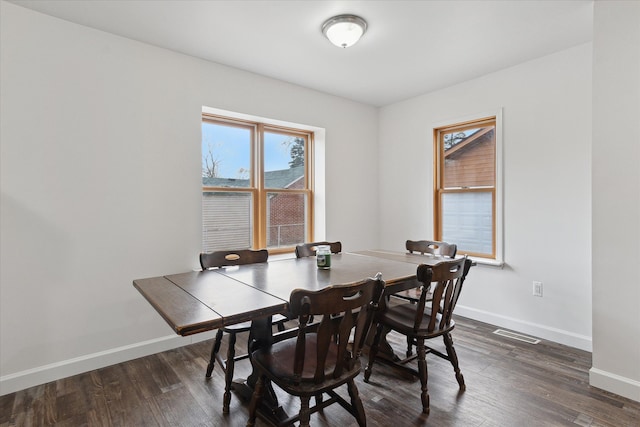 dining room featuring visible vents, baseboards, and dark wood-style flooring