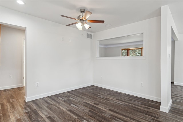 empty room with dark wood finished floors, visible vents, and baseboards