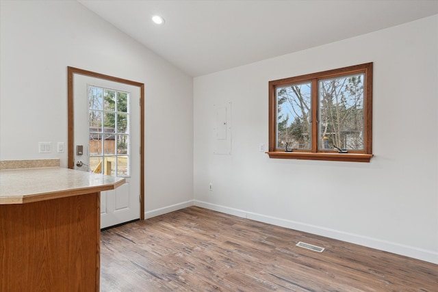 unfurnished dining area with wood finished floors, baseboards, visible vents, recessed lighting, and vaulted ceiling