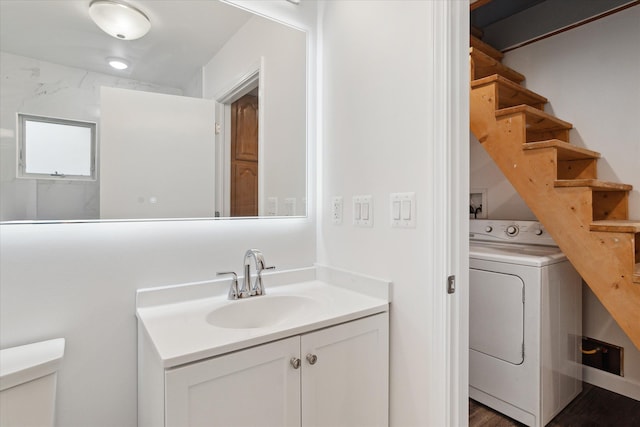 bathroom featuring toilet, washer / clothes dryer, and vanity