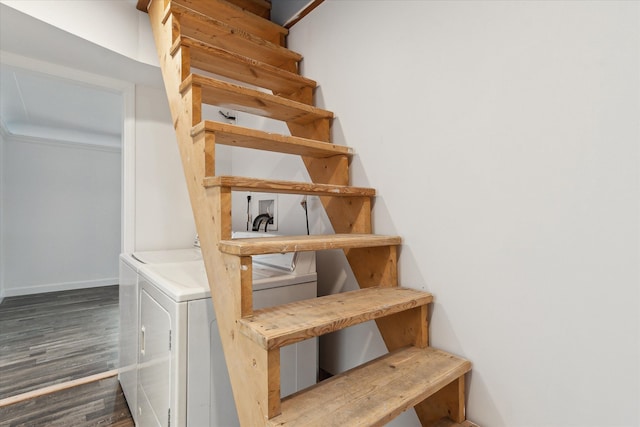 stairs with wood finished floors, washing machine and dryer, and baseboards