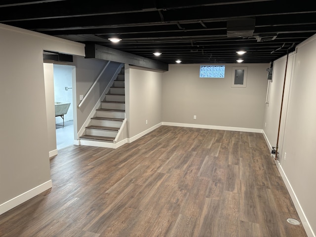 basement with dark wood finished floors, stairs, and baseboards