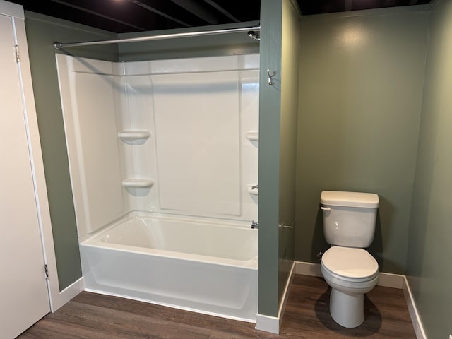 bathroom featuring bathtub / shower combination, toilet, wood finished floors, and baseboards