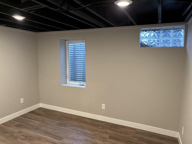 below grade area with dark wood-style floors and baseboards