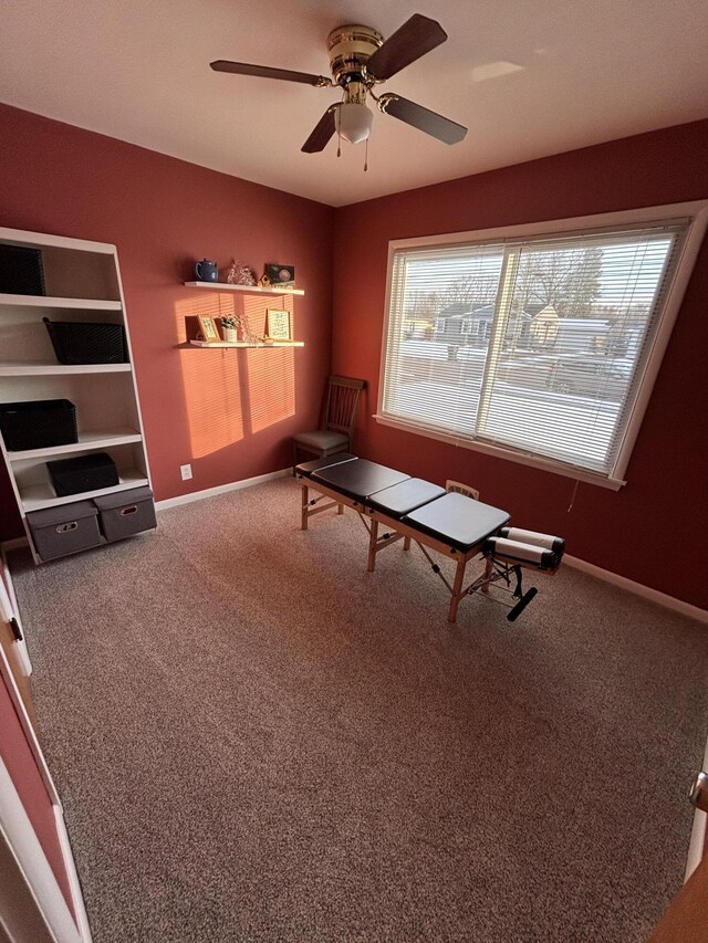 interior space with baseboards, ceiling fan, and carpet flooring