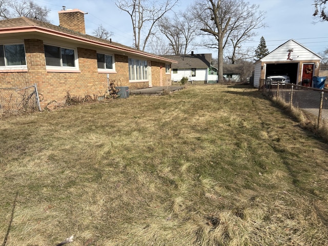 view of yard featuring an outdoor structure, central air condition unit, and fence