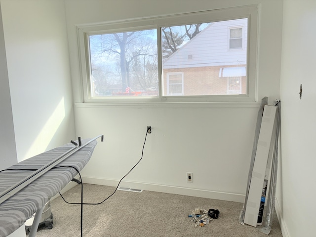 interior space with carpet flooring, a healthy amount of sunlight, visible vents, and baseboards