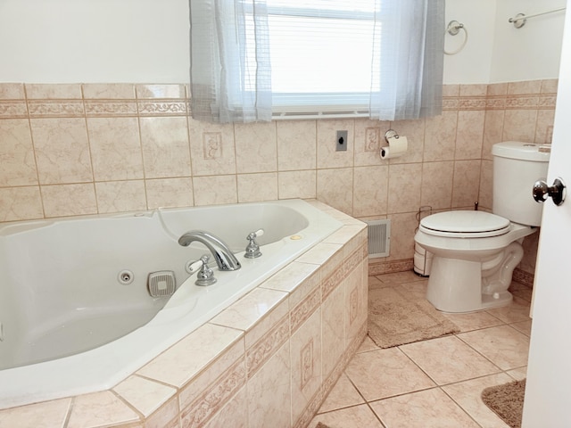 bathroom with tile patterned flooring, visible vents, a jetted tub, toilet, and tile walls