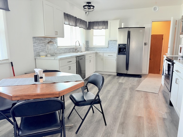 kitchen with light wood-style flooring, a sink, light countertops, white cabinets, and appliances with stainless steel finishes